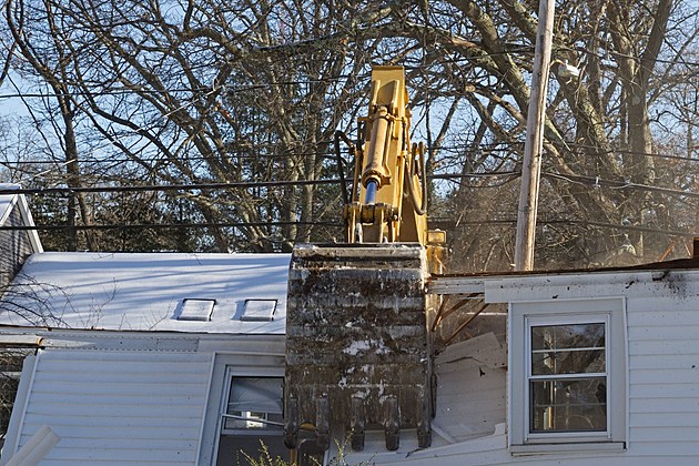 excavator tearing down a roof